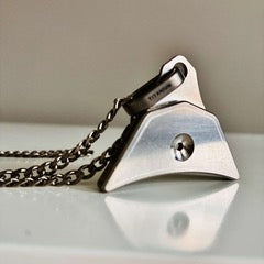 Logan Titanium whistle with chain on a reflective surface