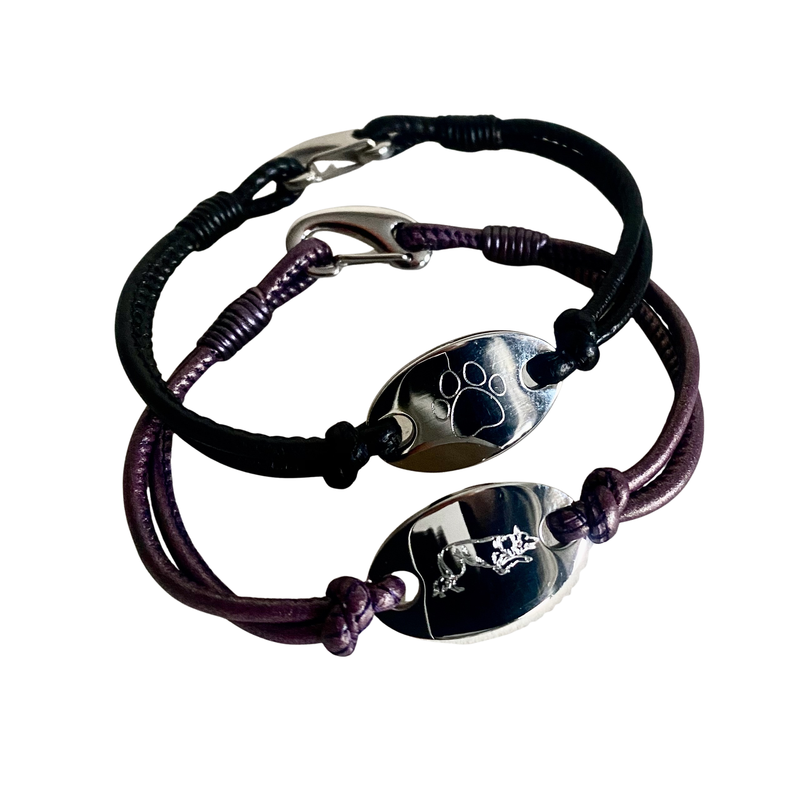 Bracelet with black and purple cord and engraved silver oval charms on a white background