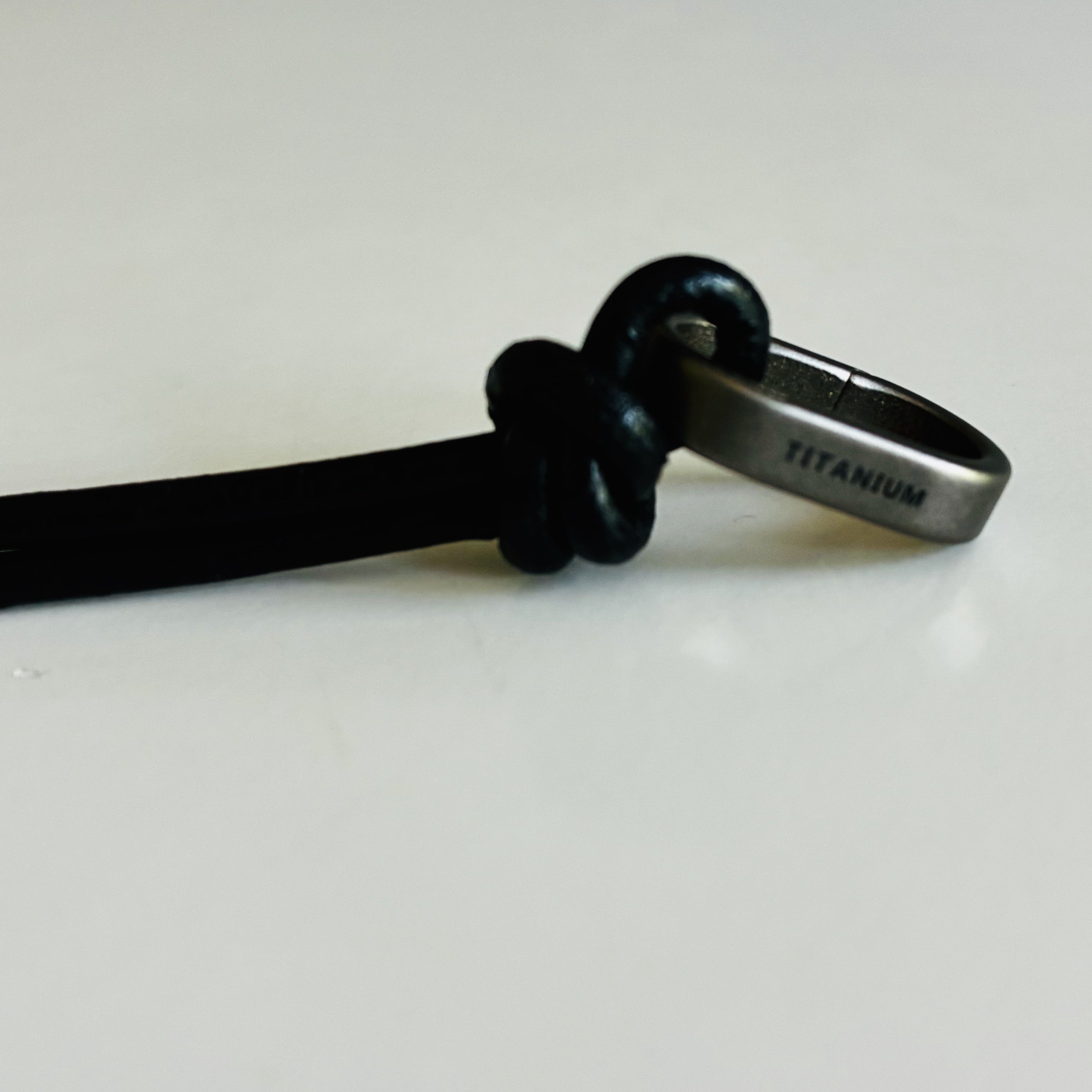 Titanium snap ring on a leather cord